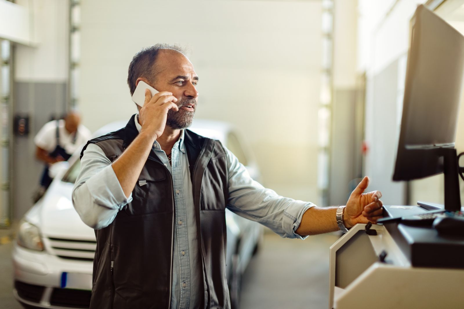 Artisan garagiste répondant au téléphone aux questions d’un client